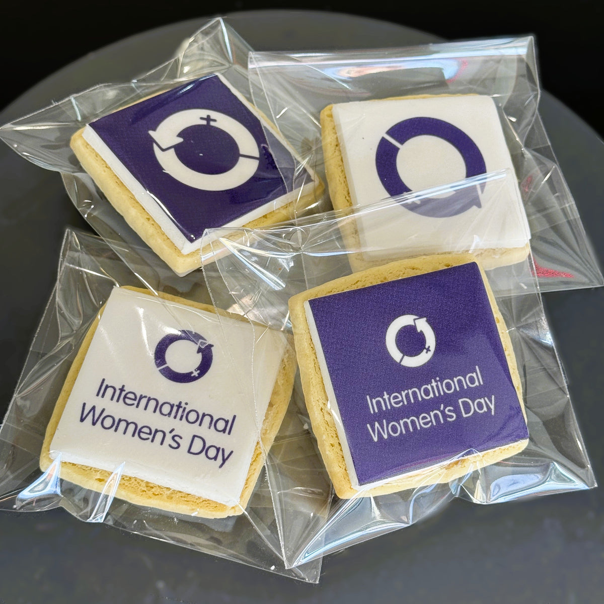Square branded cookies with the International Women's Day logo, single bagged