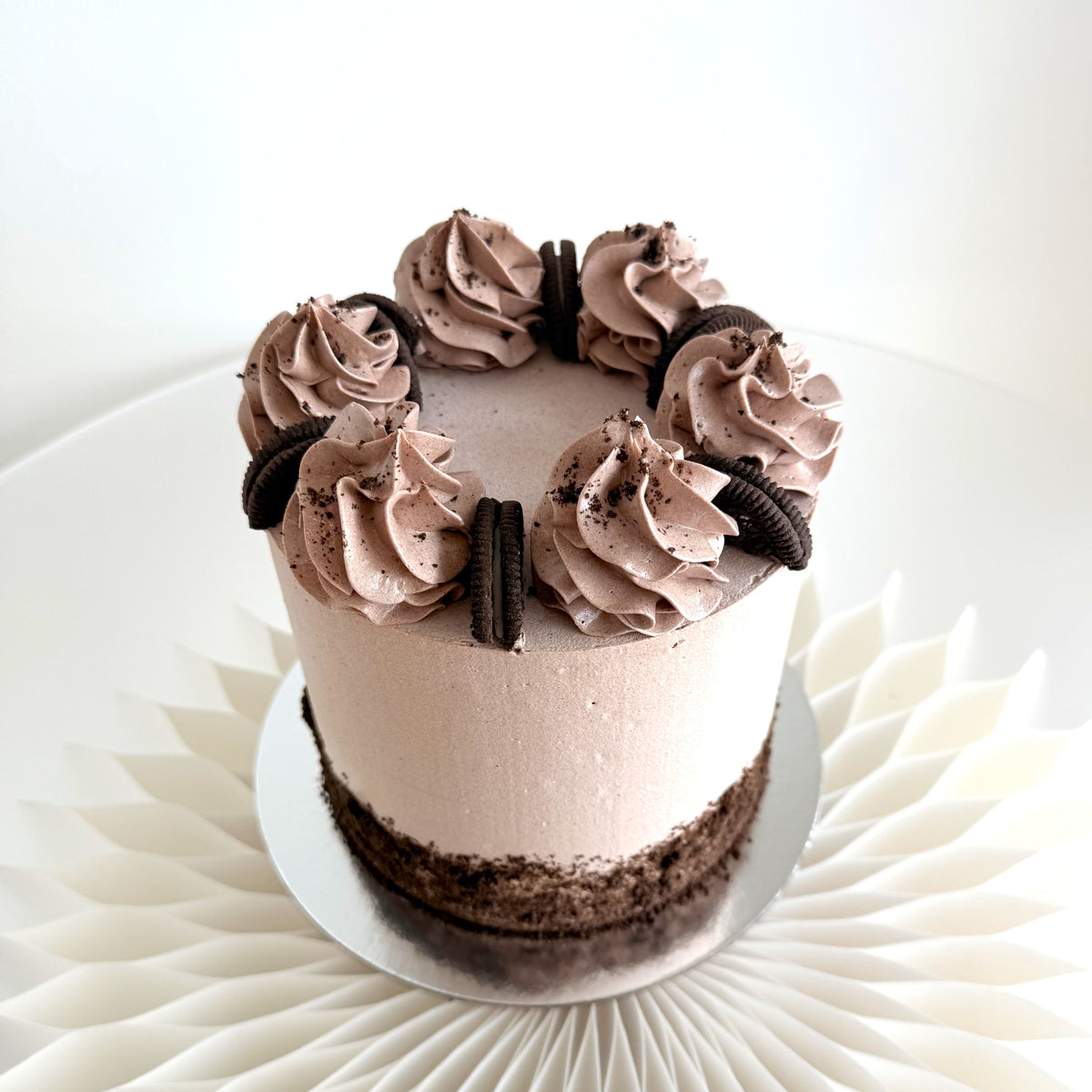 Cookies and cream party cake from above, a crown of chocolate buttercream swirls and whole chocolate cookies