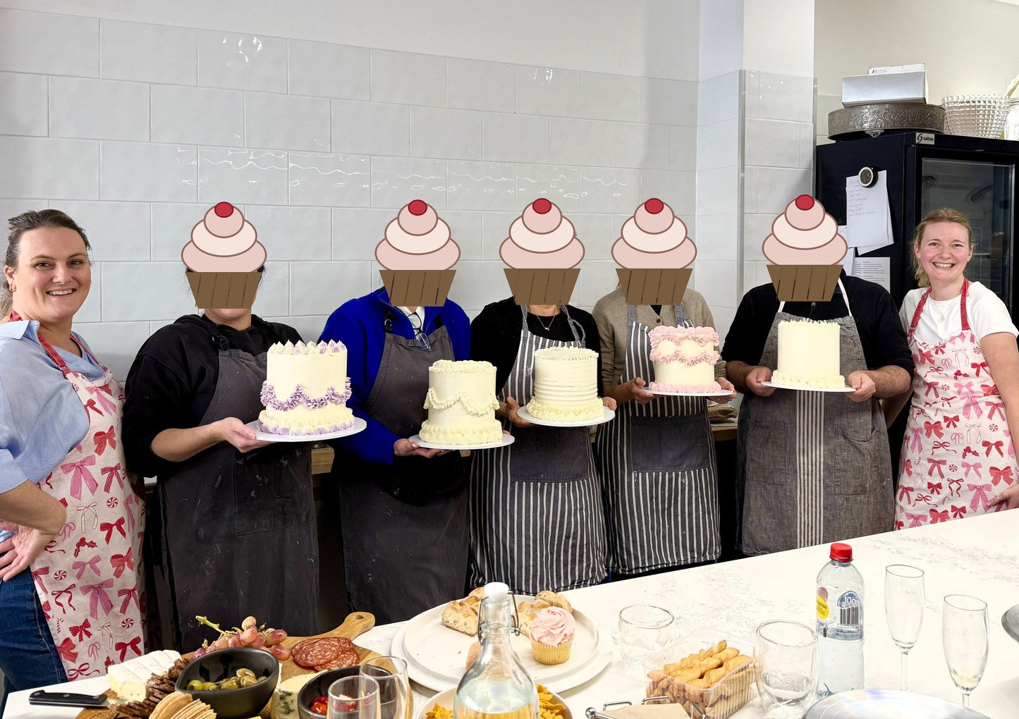 Buttercream masterclass guests holding the three layer cakes they decorated