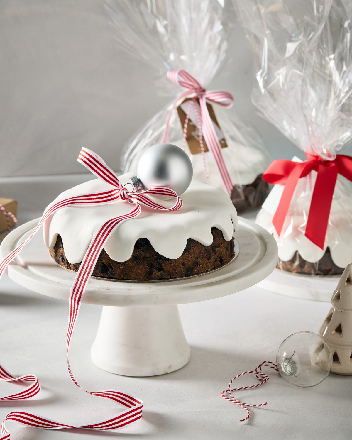 Close up of a Christmas fruit cake showing the fruit under white fondant icing
