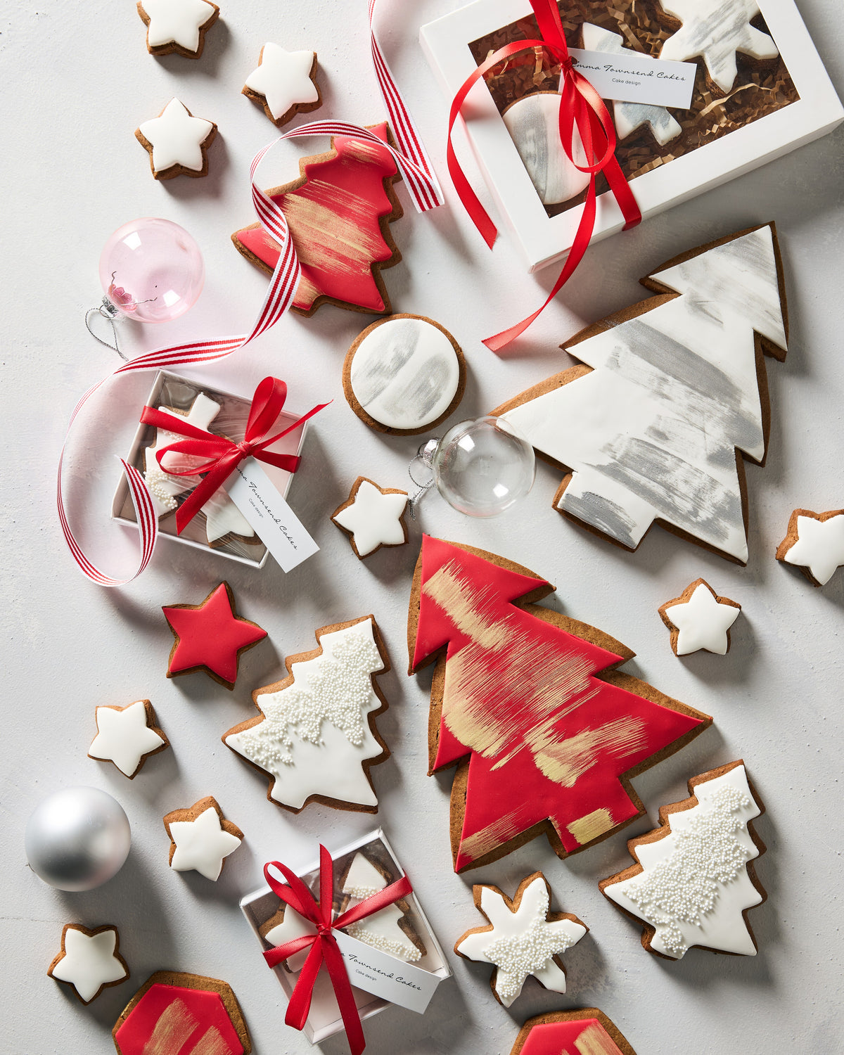 Christmas gingerbread cookie boxes tied with red ribbon among iced gingerbread trees and stars