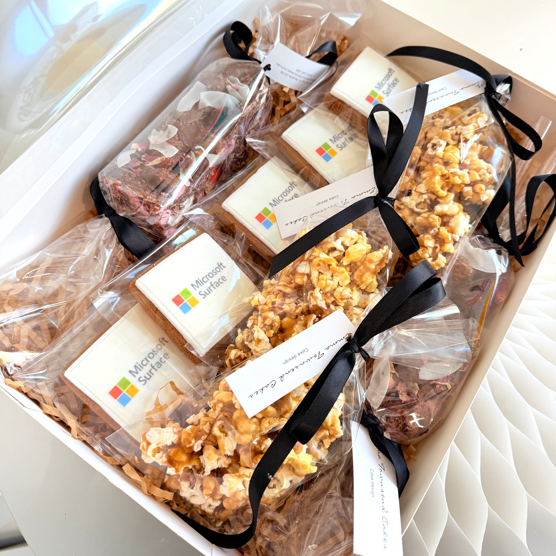 Corporate Gift Hamper open, showing branded logo cookies, caramel popcorn and rocky road bites