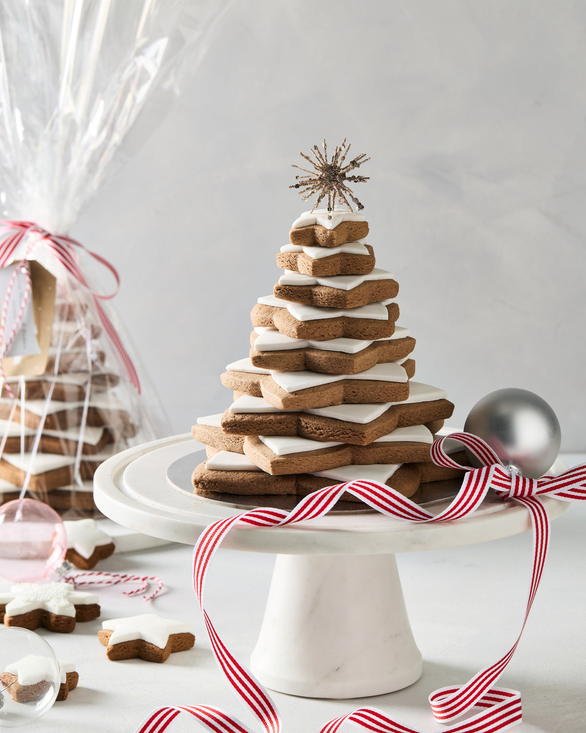Close up of a gingerbread star tree with white fondant on each star and a gold star on top