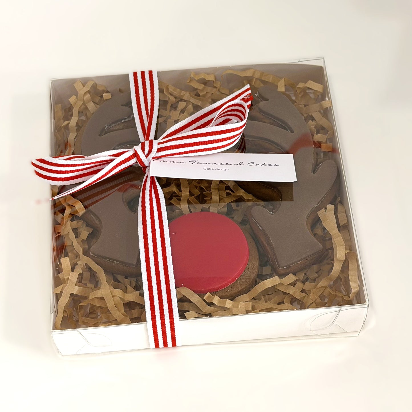 Gift box with a red lid, decorative ribbon, and a card on a white background